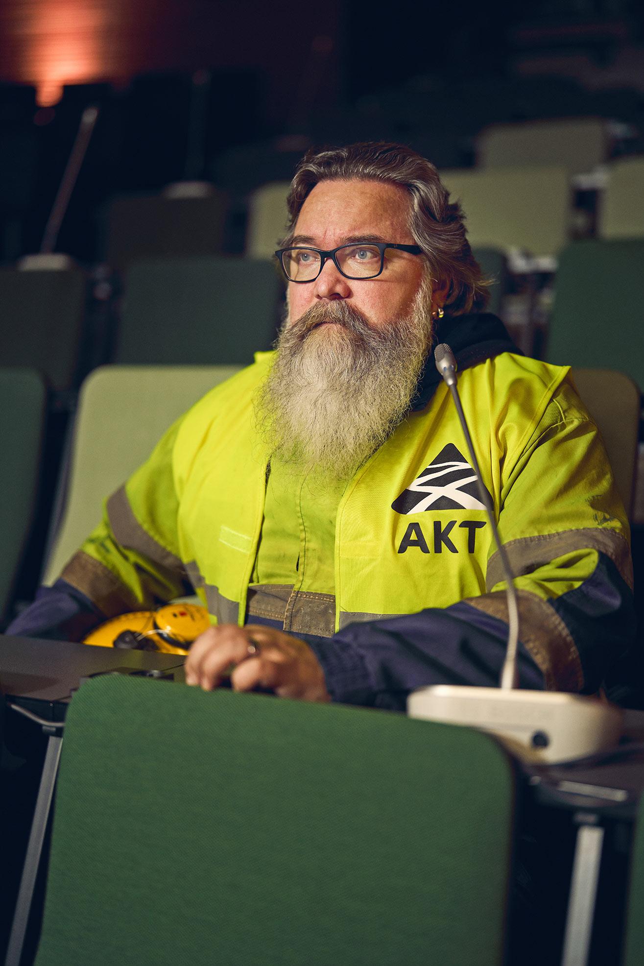 Jape Lovén istuu luentosalin tuolilla keltainen ahtaajan takki päällään.